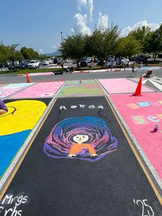 children are drawing on the ground with chalk and markers in front of them at an art festival