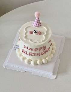 a birthday cake with white frosting and pink decorations