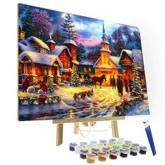 a painting on an easel with paintbrushes and paints in front of it