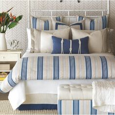 a bed with blue and white striped pillows