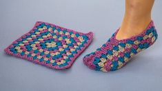 a woman's feet in crocheted slippers next to a small square