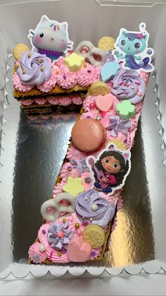 a cake shaped like the letter z is decorated with pink frosting and various cartoon characters