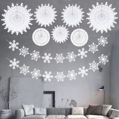 a living room filled with white furniture and snowflakes on the wall above it