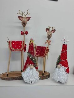 three wooden reindeer figurines with red and white outfits