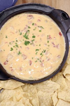 a black bowl filled with soup and chips