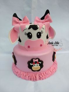 a pink and white cake with a cow on top