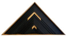 a black and gold triangle shaped object with two arrows on it's side, against a white background