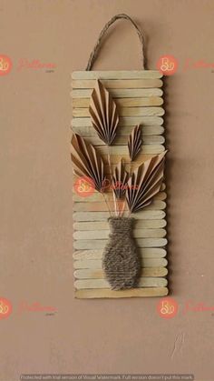 a wall hanging made out of popsicle sticks and some paper flowers on top of it