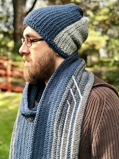 a man wearing a blue and gray scarf with a knitted hat on his head