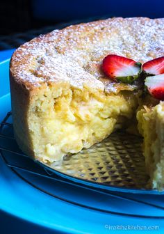 a piece of cake with strawberries on top sits on a blue plate and is half eaten