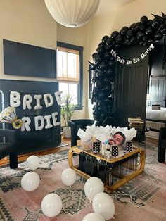 a baby is laying on a coffee table in front of some balloons and other decorations