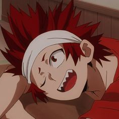 an anime character with red hair and white headband laying on the floor in bed