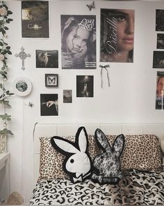 a bed with a stuffed animal on top of it next to a wall full of posters