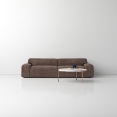 a brown couch sitting next to a white table