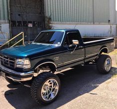 a black pickup truck parked in front of a building