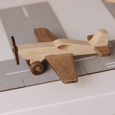 a wooden toy airplane sitting on top of a table