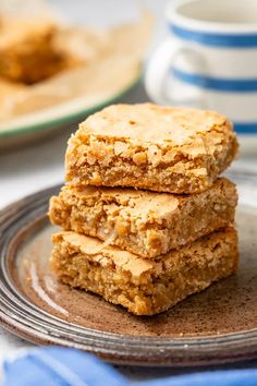 three pieces of oatmeal bars stacked on top of each other in front of a plate