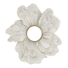 a metal flower shaped mirror mounted to the side of a wall next to a white wall