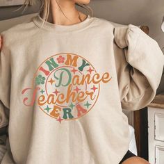 "PLEASE READ ENTIRE DESCRIPTION BEFORE ORDERING Unisex Fit Dance Teacher Sweatshirt, Funny Dancer Shirt, Choreography Sweatshirt, ballet teacher Sweatshirt, dance teacher Crewneck, Oversized, Unisex Fall in love with this soft and cozy Graphic Tee, Sweatshirt or hoodie  TO MAKE YOUR SHOPPING EXPERIENCE EASIER, YOU CAN \"CHOOSE\" A T SHIRT, SWEATSHIRT OR HOODIE IN THIS LISTING. Size up 1-2 sizes for a slouchy oversized fit PINK, Sand and light blue are NOT available in a 4X 5X Sweatshirt but they ARE  available in Tshirt Youth Kids Shirts, unisex Tshirt and Sweatshirt Available! DTG PRINTING Sweatshirt and Hoodies Sizes: S M L XL 2X 3X 4X 5X Handmade  Unisex Fit Crewneck Sweatshirts 50/50 cotton polyester  Long Sleeve TEES 100% Cotton Sizes:  Youth Tee: XS-XL Unisex Tees: S-5X *TRUE TO SIZE Stretch Letter Print Tops For Dance, Casual Crew Neck Top For Dance, Relaxed Fit Crew Neck Top For Dance, Casual Tops For Fall Dance, Crew Neck Casual Top For Dance Class, Casual Tops For Dance In Fall, Casual Letter Print Sweatshirt For Dance, Casual Crew Neck Sweatshirt For Dance, Casual Cotton Sweatshirt For Dance