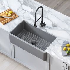 a kitchen with marble counter tops and stainless steel sink, cutting board on the counter