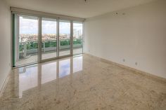 an empty living room with large windows and marble flooring in front of the sliding glass doors