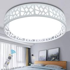 a bed room with a neatly made bed and a round light above the headboard