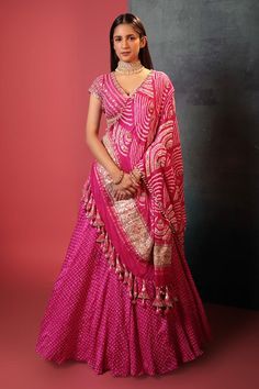 Pink attached can-can silk lehenga with all over bandhani pattern. Paired with a padded floral gota embroidered blouse and bandhani dupatta, highlighted with gota and cutdana. Components: 3 Pattern: Woven, Embroidery Type Of Work: Bandhani, Gota Neckline: V Neck Sleeve Type: Short Sleeves Fabric: Silk Color: Pink Other Details: Lehenga: Attached can-can Gota embroidered broad waistband Length: 42 inches Blouse: Padded Back tie-up detailing Length: 14 inches Dupatta: Beaded and tassel work borde Luxury Bandhani Print Dupatta For Puja, Luxury Bandhani Print Paithani Silk Dupatta, Luxury Festive Bandhani Print Dupatta, Bandhani Pattern, Orang India, Long Blouse Designs, Bandhani Dress, Lehenga Designs Simple, Indian Bride Outfits