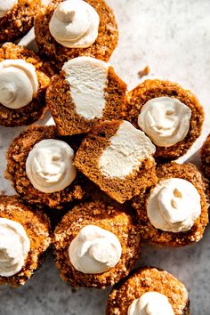 small desserts with white frosting on them are arranged on a table top, ready to be eaten