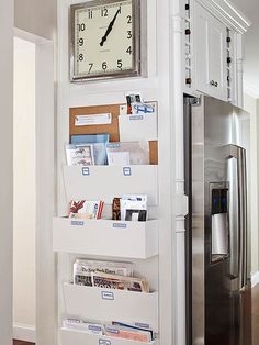 a white refrigerator freezer sitting inside of a kitchen next to a wall mounted clock