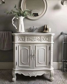 a white sink sitting under a mirror next to a wall mounted faucet in a bathroom