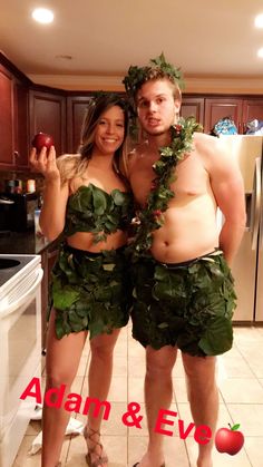 a man and woman dressed up in leafy outfits, standing next to each other