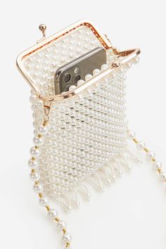 This regal and elegant clutch is completely wrapped in party-ready embellished rhinestones detailing, which sets the stage for a Roaring 20s party. Features: High quality imitation pearls Detachable chain length: 45.3 inch / 115 cm Unique kiss lock closure 3 inch / 13.5 cm x 6.5 inch / 16.5 cm ( L x H ) Elegant Chain Evening Bag As Gift, Elegant Clutch With Chain As A Gift, Elegant Chain Clutch, Elegant Clutch With Chain For Gift, Elegant Clutch With Chain Detail For Gifts, Gold Pearl Clutch For Parties, Rectangular Pearl White Evening Bag For Party, Pearl Beaded Evening Bag For Formal Occasions, Chic Pearl Embellished Evening Bag For Party