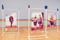 three frames with pictures on them in an art gallery, one is empty and the other two are blue