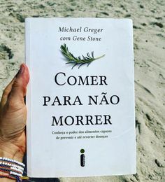 a person holding up a book in the sand