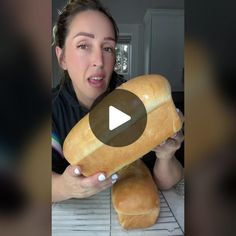 a woman holding a large loaf of bread