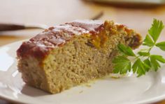 a piece of meatloaf on a white plate with parsley