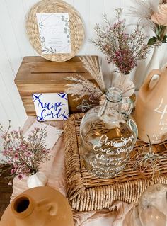 an arrangement of vases, jars and other items are on display in a wicker basket