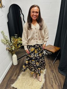 Featuring a floral print, elastic waist band, pockets and a tiered silhouette, The Jolie Midi Skirt is the perfect fall skirt! SHOP THE LOOK: Danyale styled The Jolie Midi Skirt with The Tan Waffle Knit Cardigan and our Birch Suede Booties for the perfect fall look! DETAILS: Color: Black Floral Print Elastic Waist Band Pockets Tiered silhouette Lined 70%RAYON 30%POLYESTER Model is wearing a size small. See size guide in images for more details. Measurements are approximate. Athletic Skirts, Fall Skirt, Floral Print Midi Skirt, Fall Attire, Black Floral Print, Printed Midi Skirt, Minimalist Wardrobe, Fall Skirts, Shop The Look