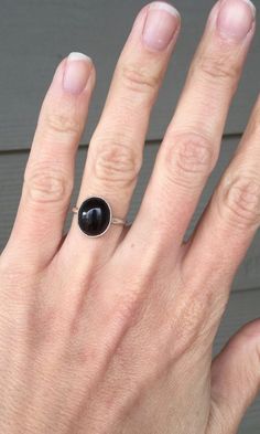 A lovely oval black onyx ring has been set in a simple sterling silver setting with a handmade ring band from sterling silver half dome wire. The stone is 12mm x 10mm in size with a height of about 8mm. This ring is simple and minimalist in style. Made to order! Minimalist Oval Onyx Jewelry, Everyday Black Onyx Rings, Simple Oval Sterling Silver Rings, Minimalist Black Oval Rings, Minimalist Onyx Oval Ring, Black Oval Minimalist Jewelry, Simple Black Sterling Silver Jewelry, Boho Rocker, Chic Rings