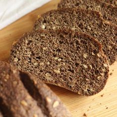 slices of brown bread sitting on top of a wooden cutting board