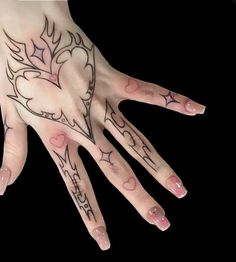 a woman's hand with tattoos on it and hearts painted on the inside of her fingers