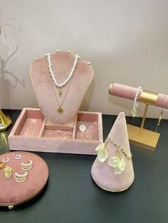 pink jewelry set displayed on black table with gold accessories