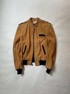 "Suede Leather Jacket Size: Men's Small Era: 1980's Material: Suede Leather  Made in Mexico Details: Light Brown Suede Leather Jacket with Black Cotton Wrist and Waist Cuffs and Pocket Trim.  Mideal Zipper  Great Condition with Minimal Wear.  No Defects, Holes, or Stains.  Chest (Armpit-Armpit) : 21\"  Sleeve (Shoulder-SleeveEnd) : 25\" Length (Neckline-Bottom) : 24\"" Vintage Brown Retro Leather Jacket For Winter, Retro Leather Jacket For Winter Workwear, Retro Winter Leather Jacket For Work, Vintage Brown Outerwear For Winter Streetwear, Retro Vintage Brown Biker Jacket For Fall, Vintage Brown Biker Jacket With Pockets, Vintage Leather Jacket For Winter Streetwear, Vintage Brown Biker Jacket For Streetwear, Vintage Winter Biker Jacket With Pockets