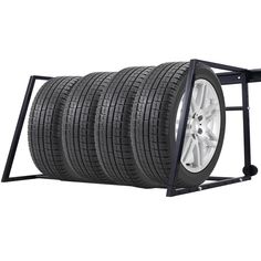 four tires are stacked on top of each other in a metal rack with wheels attached