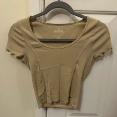 Beige Hollister Ribbed Baby Tee Size Small Never Worn In Great Condition Trendy Ribbed Beige Top, Trendy Beige Ribbed Top, Beige Ribbed Cotton Top, Casual Cream Ribbed Top, Brown Ribbed Short Sleeve Top, Fitted Neutral Ribbed Top, Neutral Ribbed Tops For Spring, Neutral Fitted Casual Tops, Fitted Neutral Casual Tops