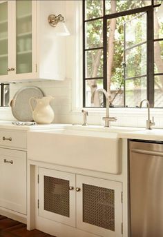 a kitchen with white cabinets and stainless steel appliances, including a dishwasher in the center