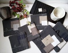 several pieces of black and white quilted placemats on a table next to a vase with flowers