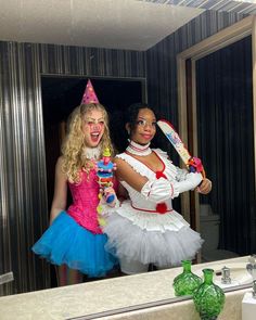 two women dressed up as clowns in front of a mirror