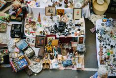 an overhead view of a table with many items on it and people looking at them