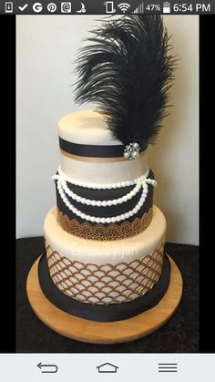 a three tiered cake with black feathers on top